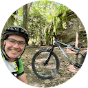 Patrick Wigley on a mountain bike trail, wearing a green jersey and helmet